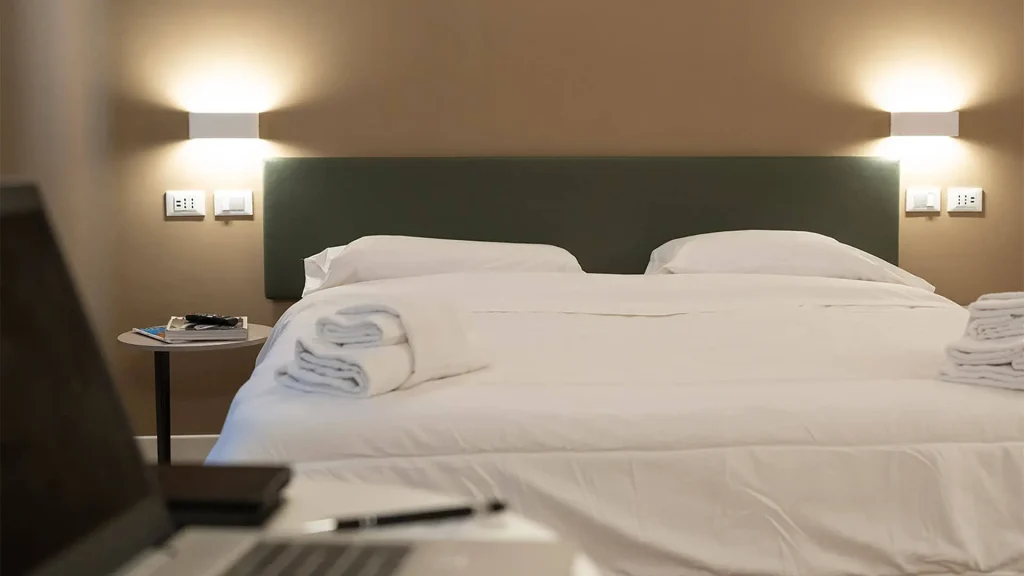 Camera da letto moderna con biancheria bianca.