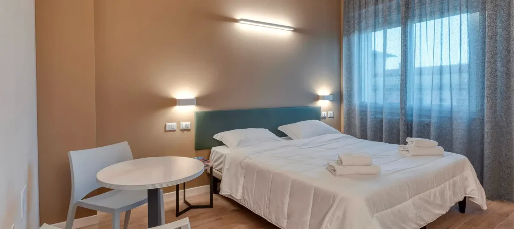 Camera da letto moderna e luminosa con tavolo.