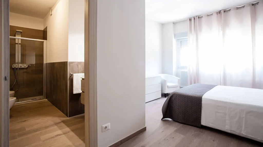 Camera con bagno, arredamento moderno e luminoso.